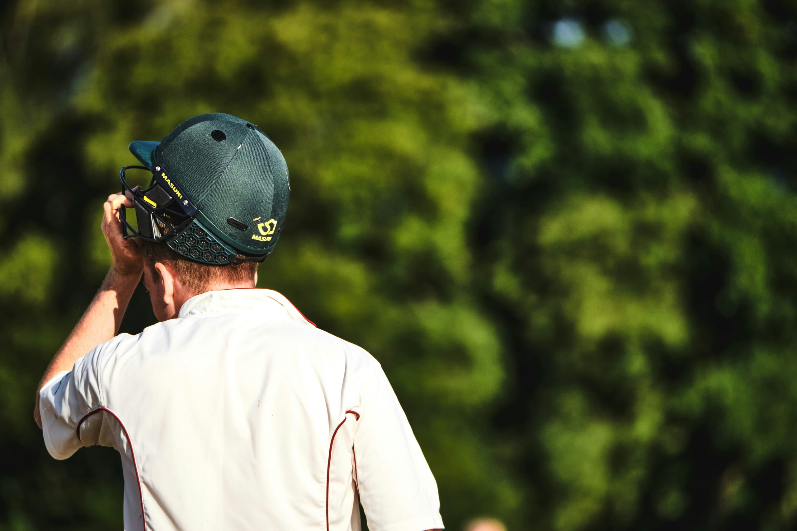 Titan Cricket Helmet — ABS-shell helmet with a fixed titanium-finish grille and adjustable occipital retention.