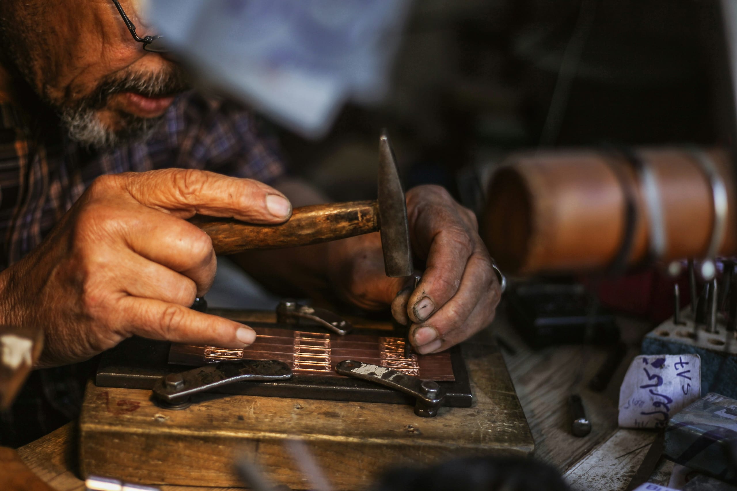 A VEXORA craftsman finishing leather components by hand